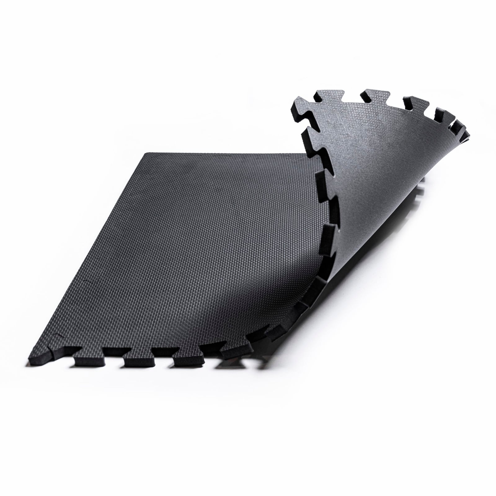 Two interlocking foam floor tiles on white, one lifted to show the interlocking teeth